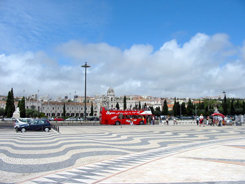 A sweeping exterior view of the massive and ornate limestone facade of the Jerónimos Monastery in Belém, Lisbon