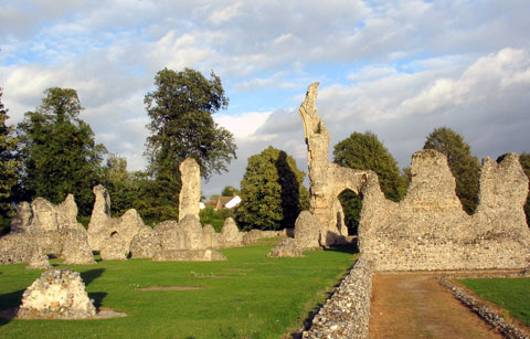 The stark, weather-beaten flint stone walls and standing ruins of Thetford Cluniac Priory under an open sky