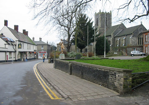 A view looking down historic King Street in Thetford, featuring the Bell Inn and the tower of St Peter's Church